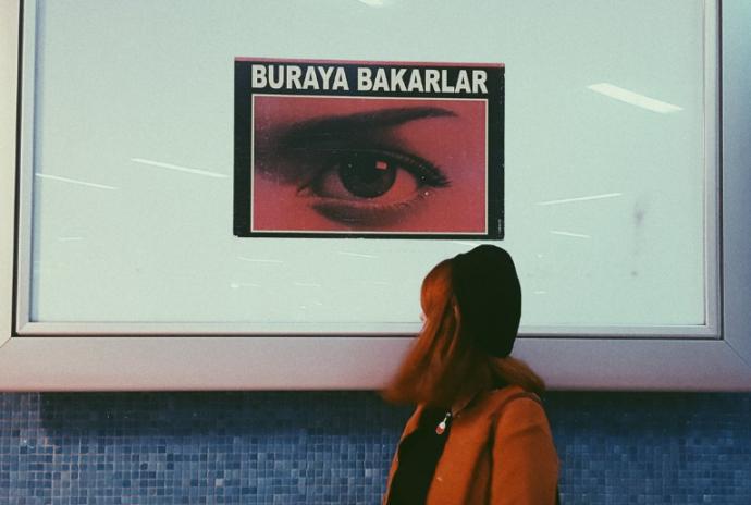 Buraya Bakarlar reklam panosu, metroda bekleyen bir kadın